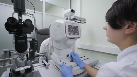 woman doctor is viewing through ophthalmoscope in eyes of patient in ophthalmologic clinic. professional inspection of vision