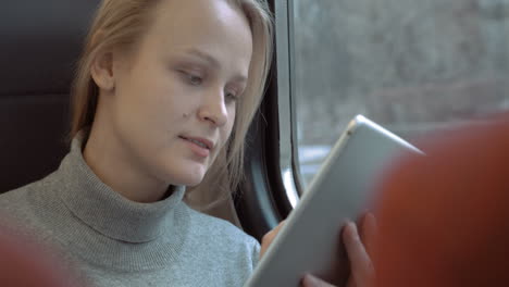 smiling woman with tablet in train