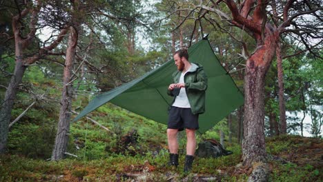 man with hammock camping shed in wilderness