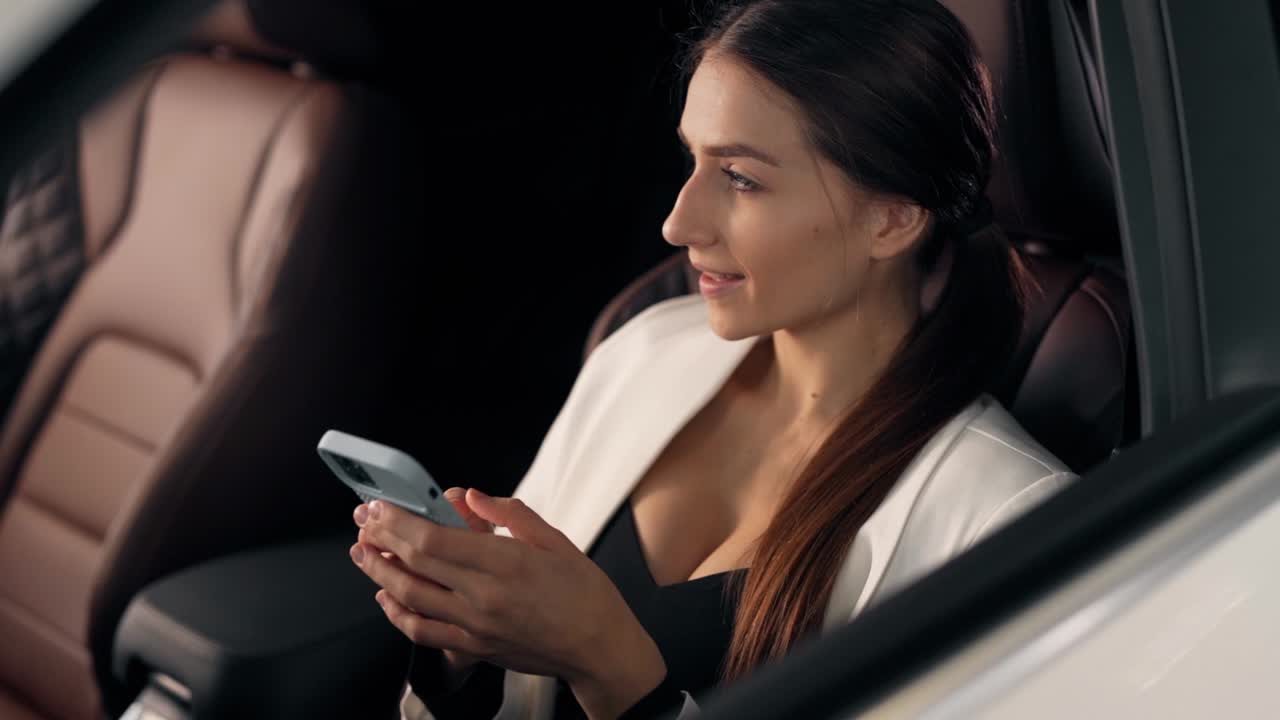 bella chica sonriente con un smartphone en el coche