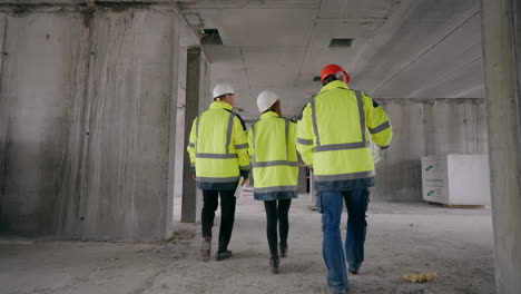 three civil engineers are walking in under-construction building real estate due diligence