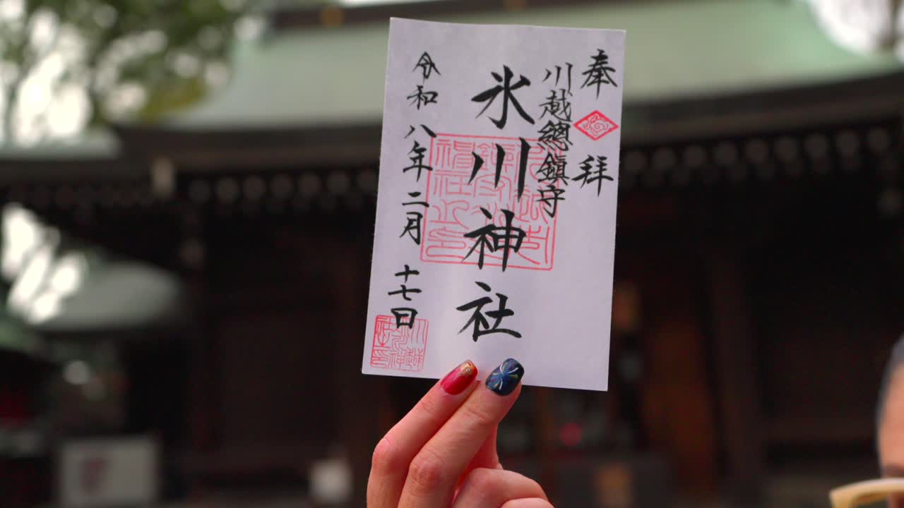 Một nữ du khách cầm con dấu Goshuin tại đền Kawagoe Hikawa, một địa điểm văn hóa và tâm linh nổi tiếng ở Nhật Bản, thể hiện một tập tục truyền thống