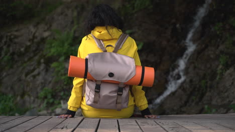 mujer caminando cerca de una cascada