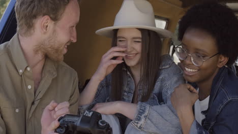 Ein-Junger-Fotograf-Zeigt-Die-Bilder,-Die-Er-Während-Eines-Roadtrips-Zwei-Schönen-Jungen-Mädchen-Im-Wohnwagen-Gemacht-Hat-5