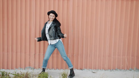woman dancing in front of pink wall