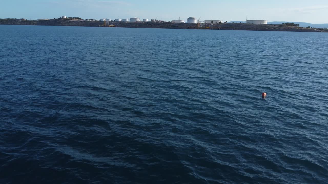 산업과 탱크, 파이프라인을 갖춘 크로아티아 섬을 향한 드론의 저고도 비행