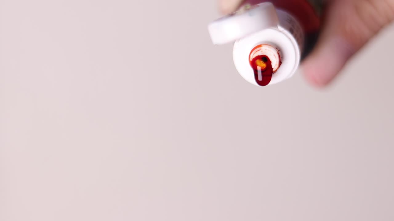 Close up of Orange food colouring being dripped out