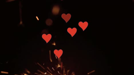 Animation-of-hearts-falling-over-fireworks-on-black-background