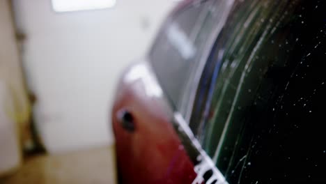 spraying water washing soap off car roof