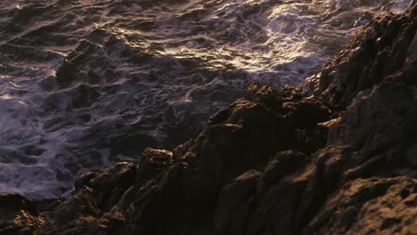 una ola chocando contra las rocas en la isla de madeira