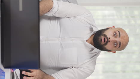 vertical video of home office worker man looking at camera confused.