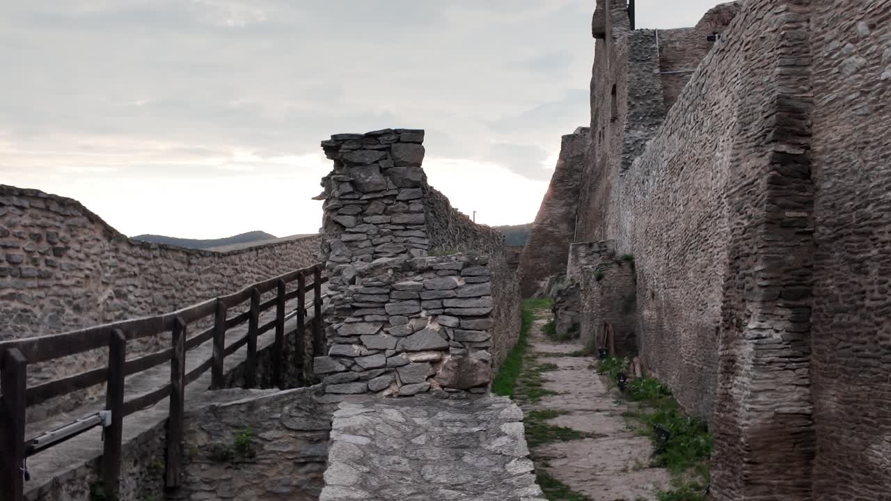 Majestic view of the Fortress of Deva in Romania, with its ancient walls contrasted by dramatic skies above the Transylvanian landscape