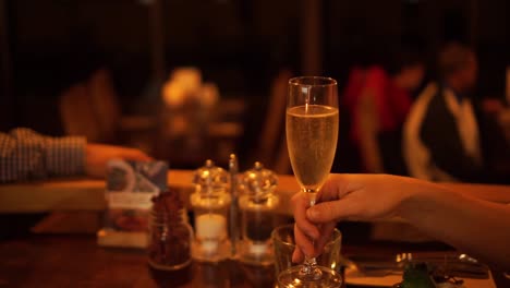 couple in luxury restaurant cheers with glasses of champagne