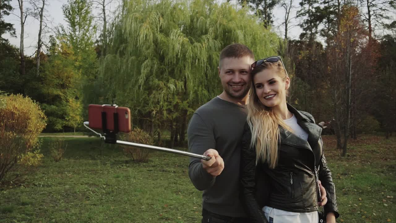 пара делает селфи в осеннем парке.