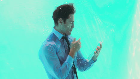 businessman underwater using his tablet