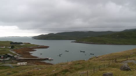 fishermen work on a dock as a small fishing motorboat drives into the bay