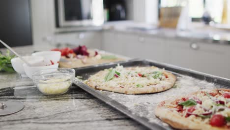 pizzas on tray in modern kitchen ready to cook in slow motion