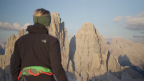 female climber walking in front of the famous three peaks - tre cime