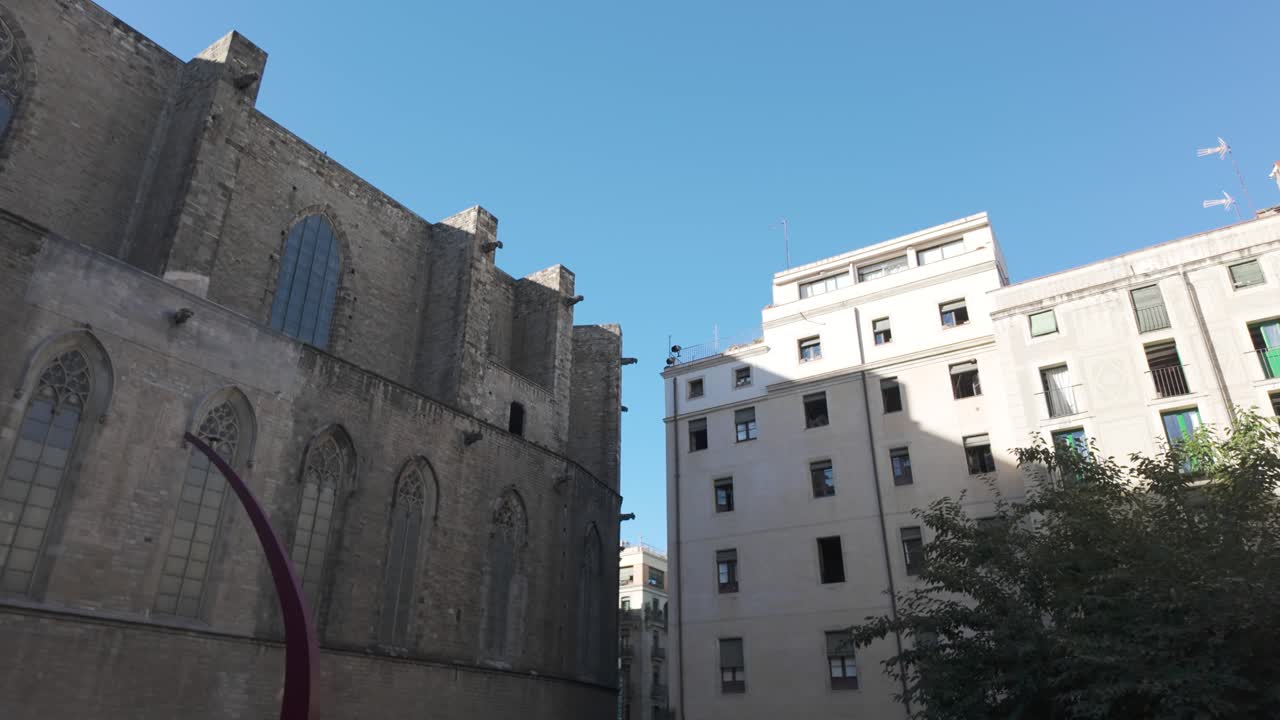 바르셀로나에 있는 역사적인 바실리카 데 산타 마리아 델 마르 (basilica de santa maria del mar) 의 풍경, 그 웅장한 전면과 우아한 고 양식의 창문, 진정된 푸른 하늘 아래, 시대를 초월하는 매력과 예술적 유산을 포착합니다.