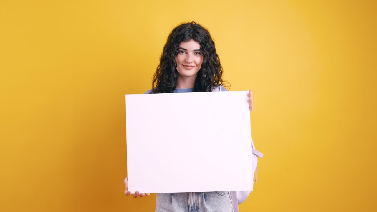 Woman holding a blank sign against a yellow background