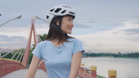 woman cycling on a bridge