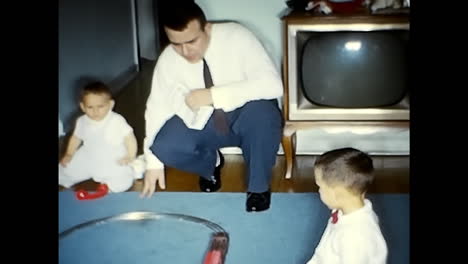 little boy playing with toy train set in 1970s usa. circa usa - 1970s: a little boy joyfully plays with a toy train set on a vintage video from the 1970s in the united states of america.