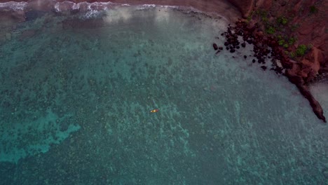 increíble video aéreo de drones de turistas remando en un colorido kayak en el destino exótico tropical de hawai con una superficie oceánica tranquila de color turquesa