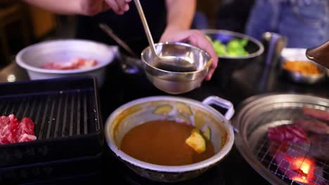 person ladling soup into a bowl