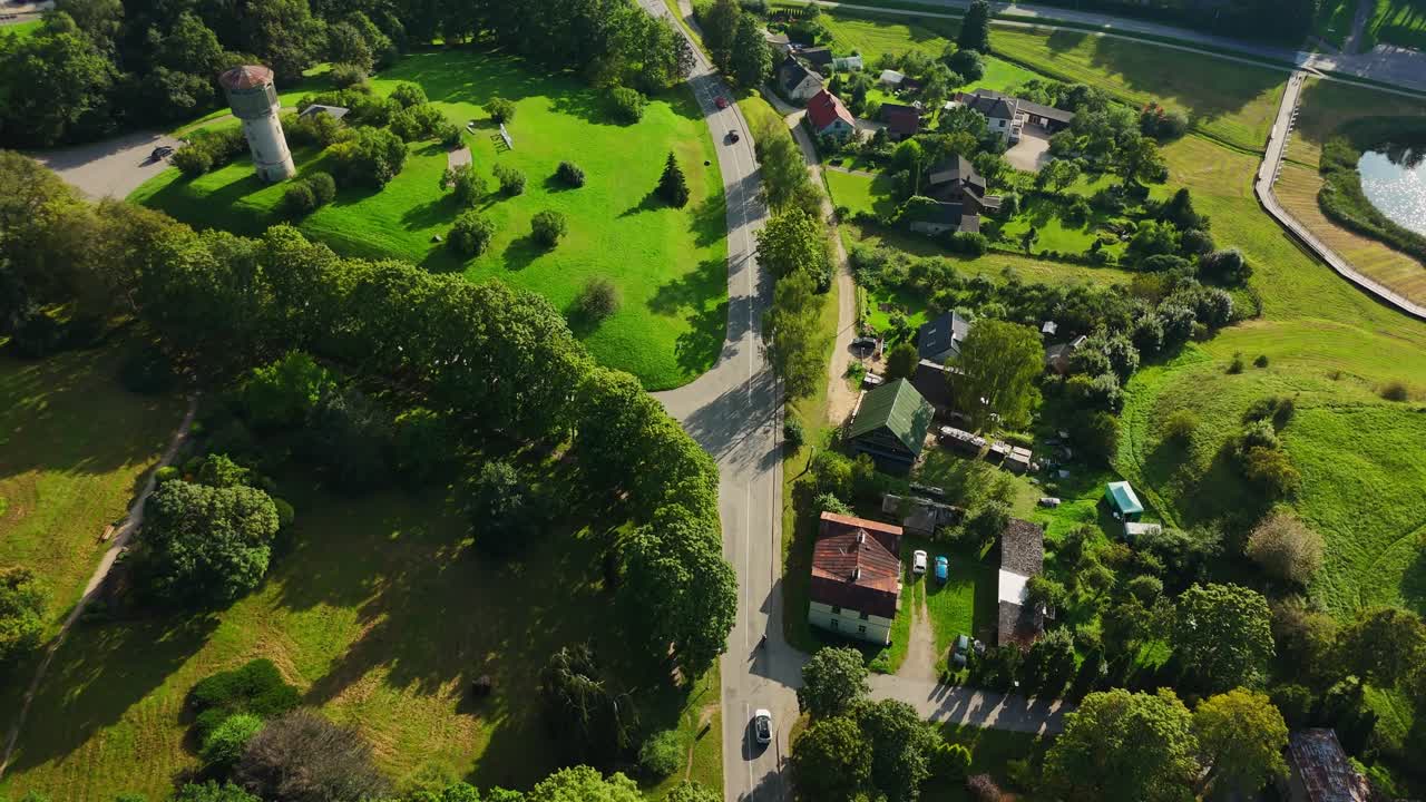 Aerial view revealing Talsi landscape, traditional wooden houses nestled among lush greenery, showcasing charming Latvian architectural heritage and pastoral scenery