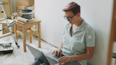 mujer trabajando en una computadora portátil durante la renovación de la casa