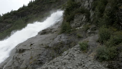 una cascada corre por una ladera de la montaña de alaska en cámara lenta