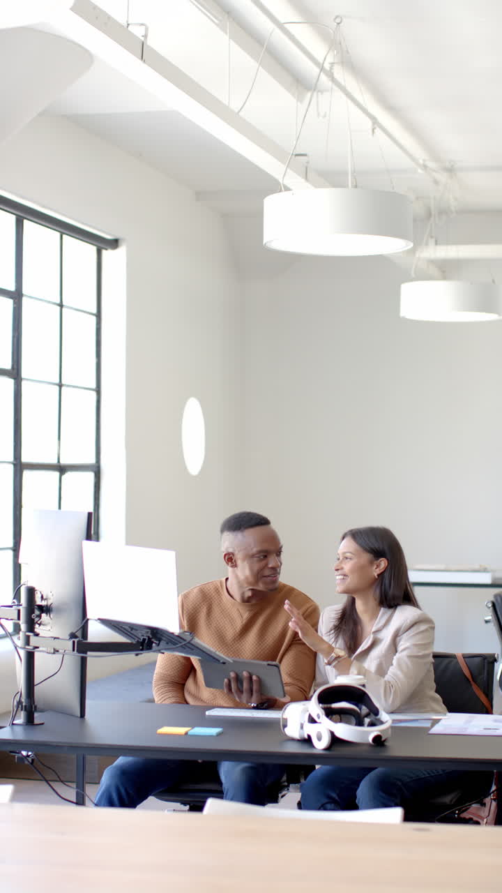 Video verticale: In ufficio, colleghi di lavoro che collaborano a un progetto usando un laptop e documenti.