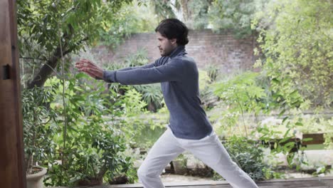 caucasian man practicing yoga in sunny nature, slow motion