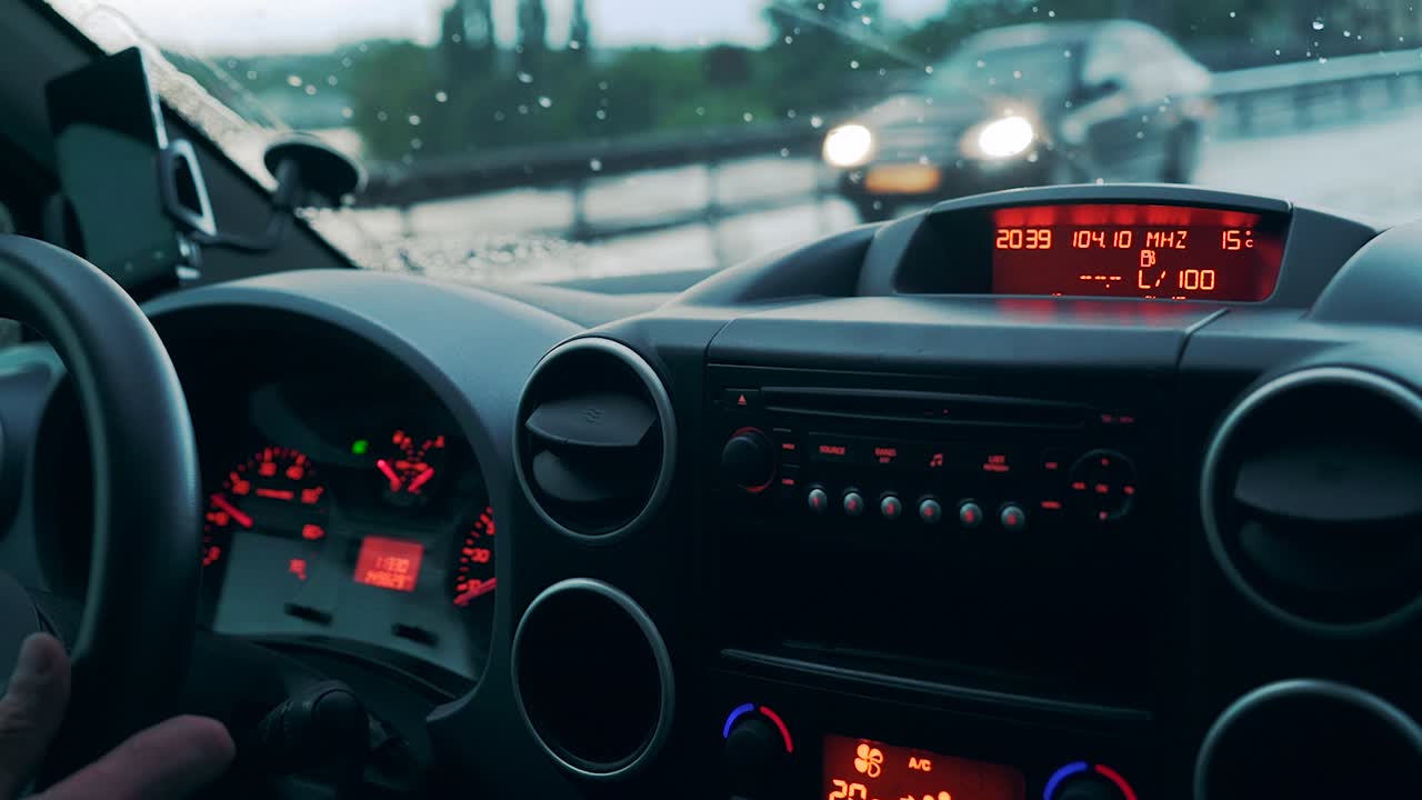 Car dashboard and wet windshield from a heavy rain in a heavy traffic. Close-up