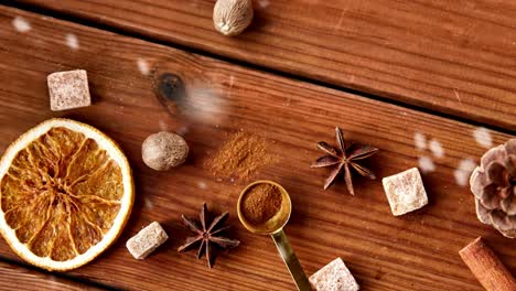 Christmas-Spices-on-Wooden-Background.christmas,-cooking-and-seasonal-concept-–-snow-falling-over-aromatic-spices-on-wooden-background