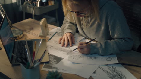 woman sketching comic book panels at a desk