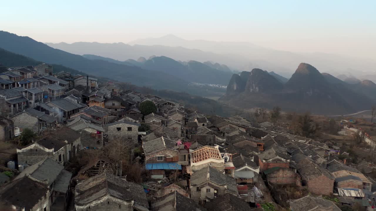 volar sobre el antiguo pueblo chino ubicado en el lado oscuro de la montaña por la noche