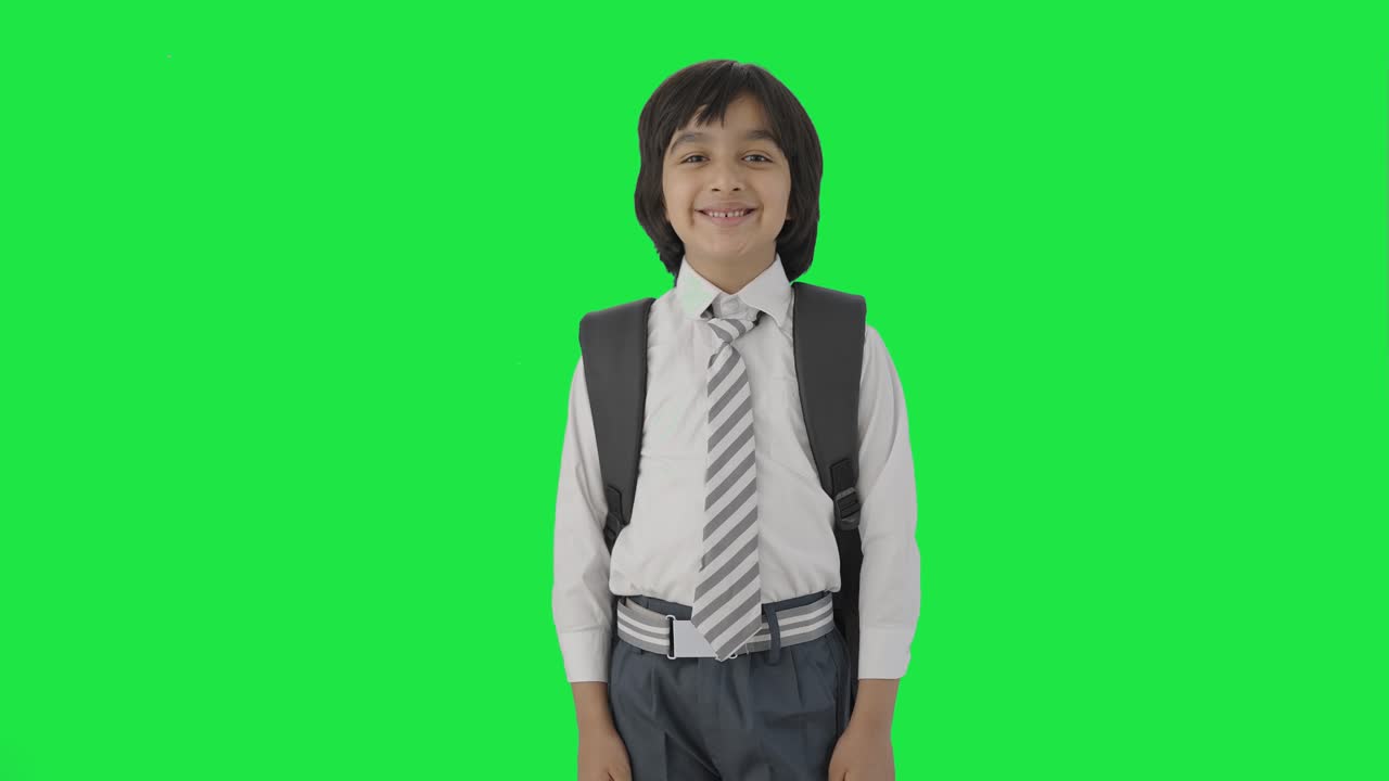 niño de escuela indio feliz sonriendo a la cámara pantalla verde