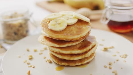 Video-of-pancakes-on-plate-seen-from-above-on-wooden-background