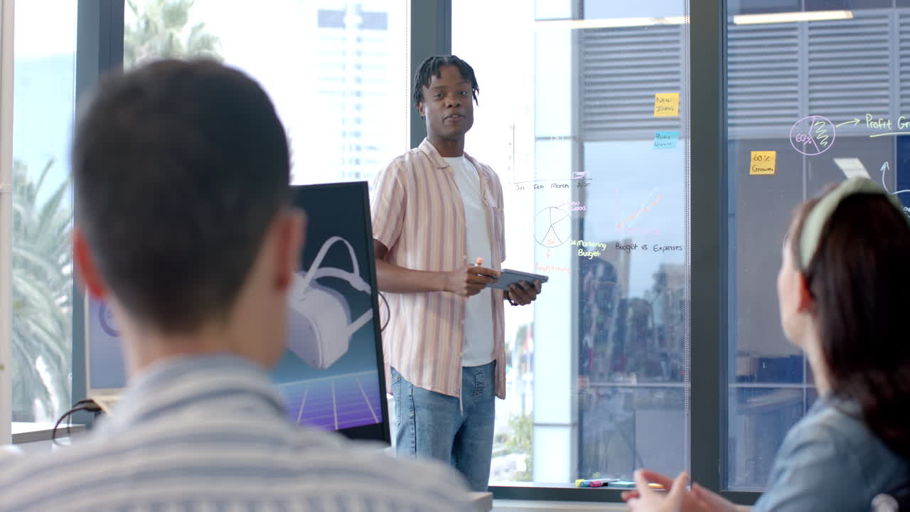 Presenting project, man holding tablet and explaining data to colleagues in office