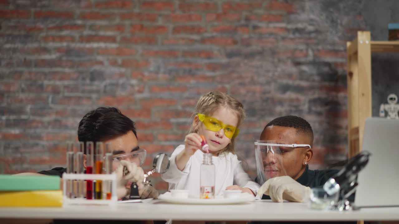 소녀와 과학자들은 액체와 페인트를 실험합니다.