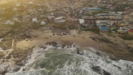 Wellen,-Die-Bei-Sonnenuntergang-Auf-Den-Felsen-Des-Strandes-Von-Punta-Del-Diablo-In-Uruguay-Zusammenbrechen