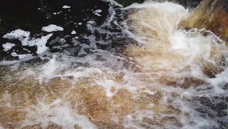 slow-motion, close-up of water flowing from a local canal