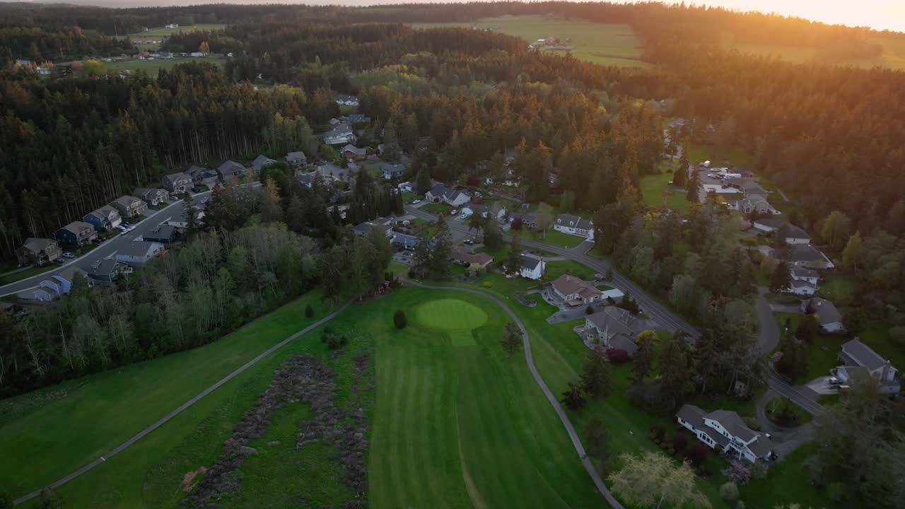 Aerial of neighborhood surrounding a golf course on Whidbey Island at sunset.
