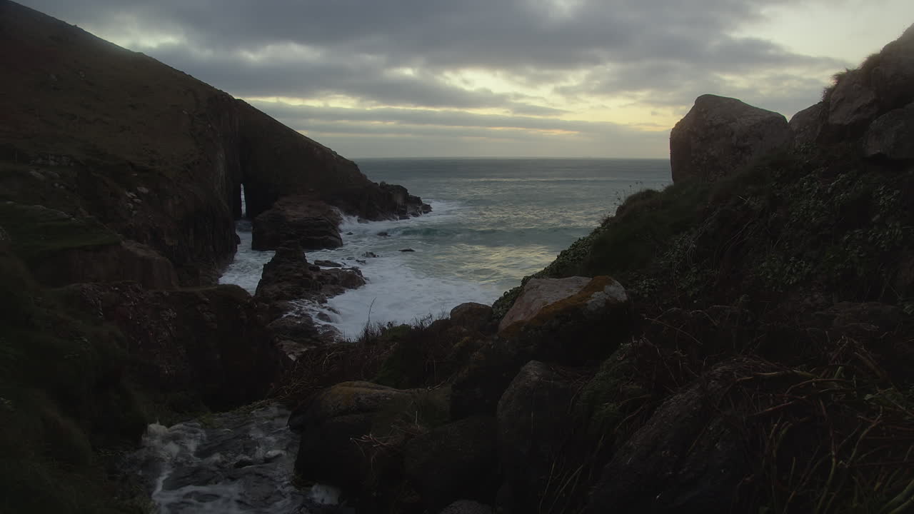 costa rocosa de nanjizal cove y playa golpeada por las olas del mar al atardecer en inglaterra, reino unido