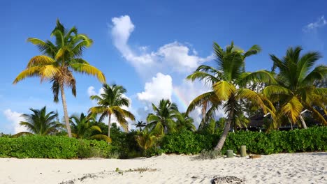 Video-Estático-De-Una-Escena-De-Playa-Tropical-En-Exuma-Bahamas-Con-Un-Pequeño-Arco-Iris-En-Las-Nubes.