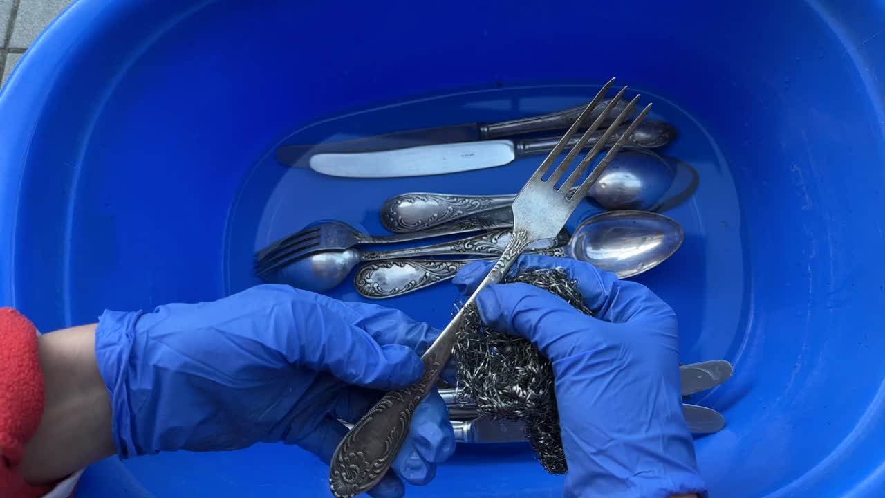 Washing Vintage Silverware in a Blue Bowl
