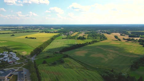 Luftaufnahme-Von-Oben-Von-Einer-Fliegenden-Drohne-Eines-Landes-Mit-Gesäten-Grünen-Feldern-Auf-Dem-Land-An-Einem-Frühlingstag