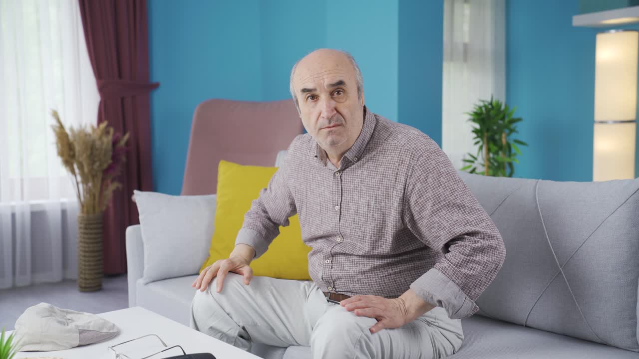 Anziano preoccupato che guarda timidamente la telecamera