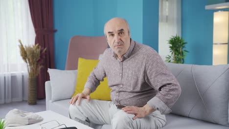 un anciano preocupado mirando tímidamente a la cámara.
